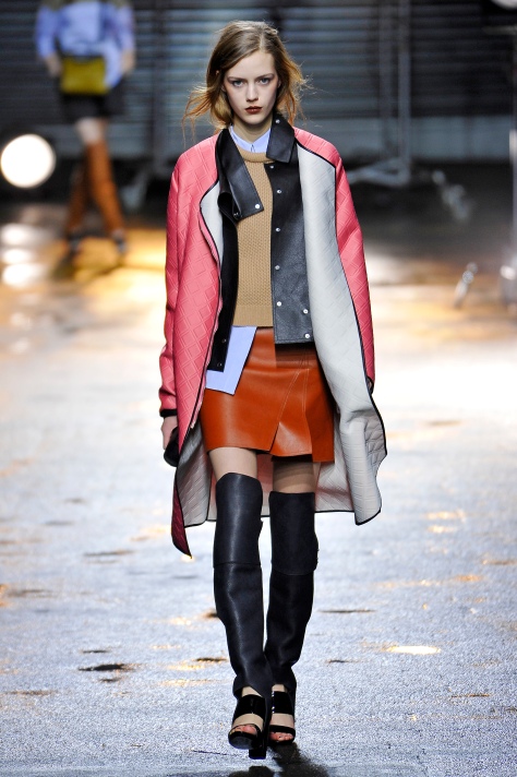 Phillip Lim, Coat: Grapefruit embossed neoprene overcoat with detachable leather bib; Pullover: Camel roll neck cropped pullover; Shirt: Blue pinstripe cropped sleeveless shirt; Skirt: Cognac leather layered mini skirt; Shoes: Black ‘Ora’ over the knee boot sandal, Fall 2013 
